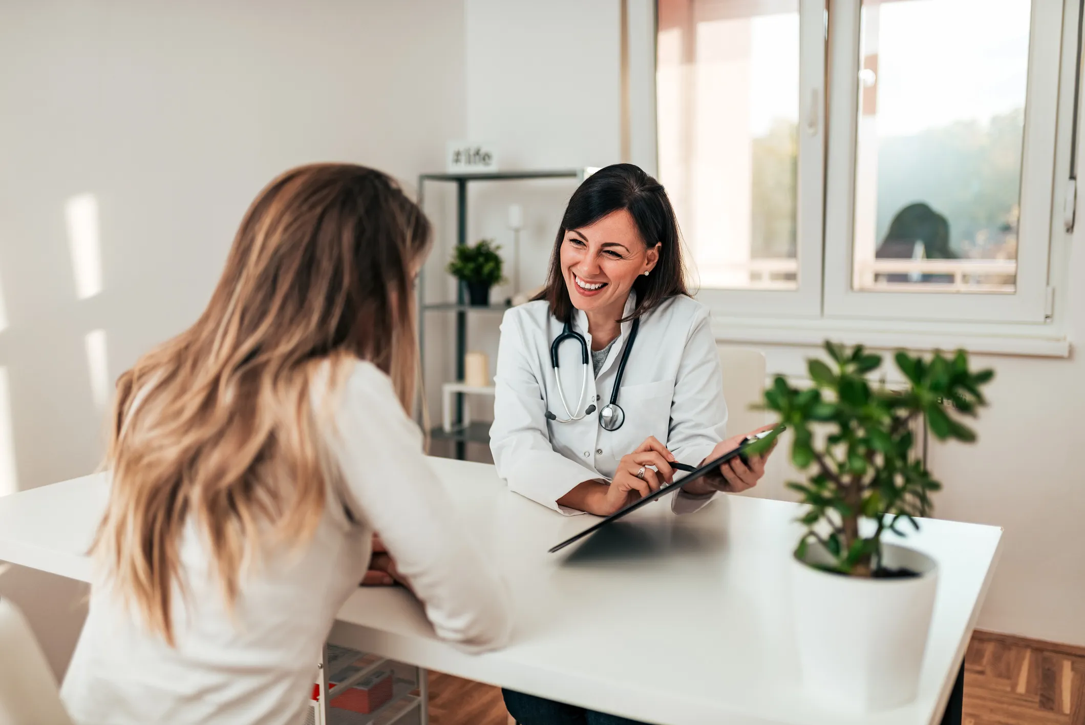 Médica conversando com paciente sobre laudo de microbiota intestinal ou de perfil genético